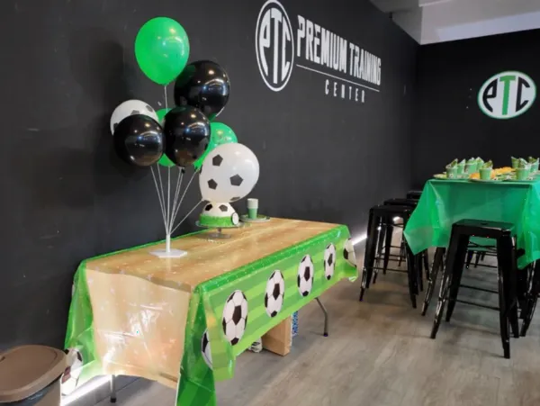 Mesa decorada con globos de fútbol para un cumpleaños en Premium Training Center