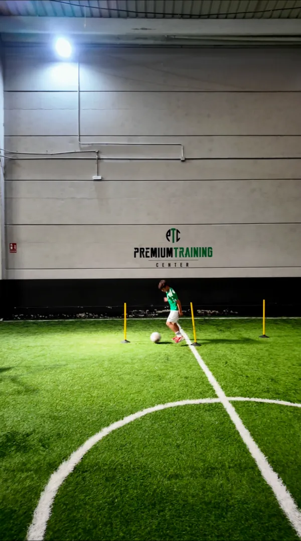 Jugador conduciendo el balón en una sesión de tecnificación en el campo indoor de Madrid